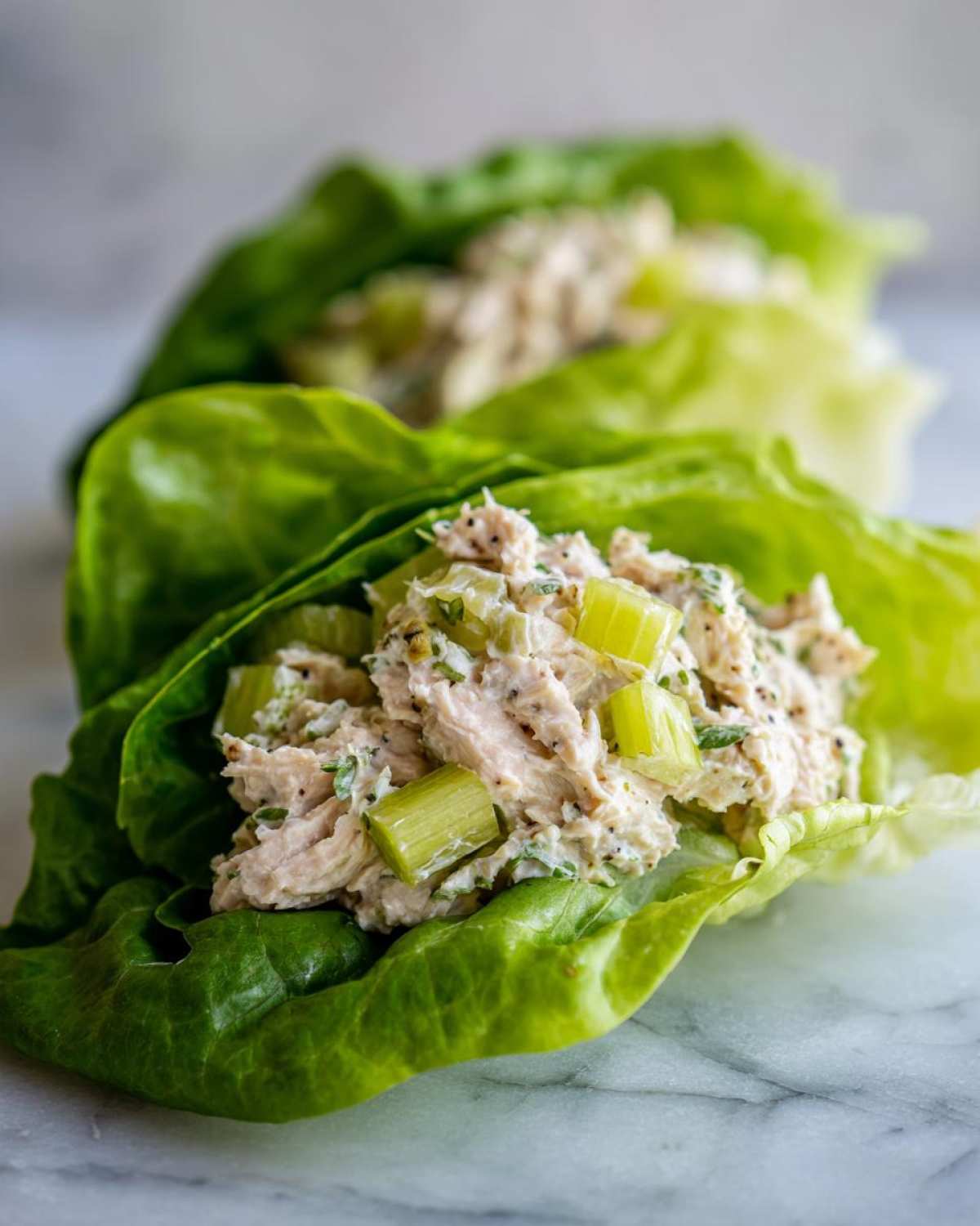 Close-up of tuna salad with celery served in bright green lettuce cups, showing the Easiest Way to Eat.